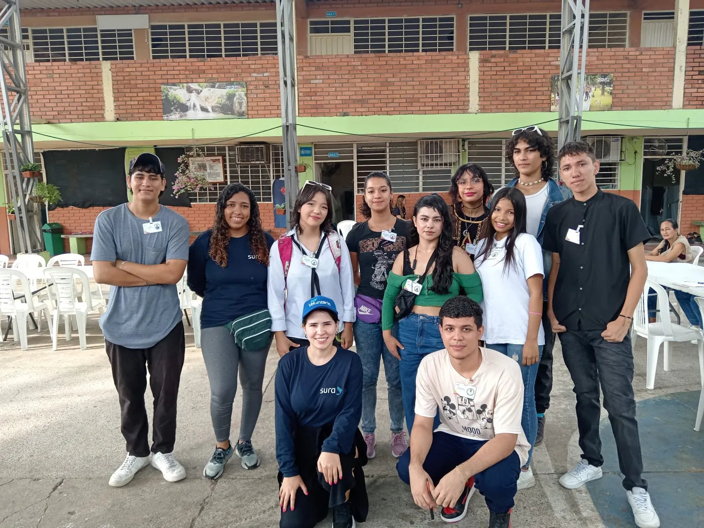 Grupo de jóvenes participantes de un programa social reunidos al aire libre.