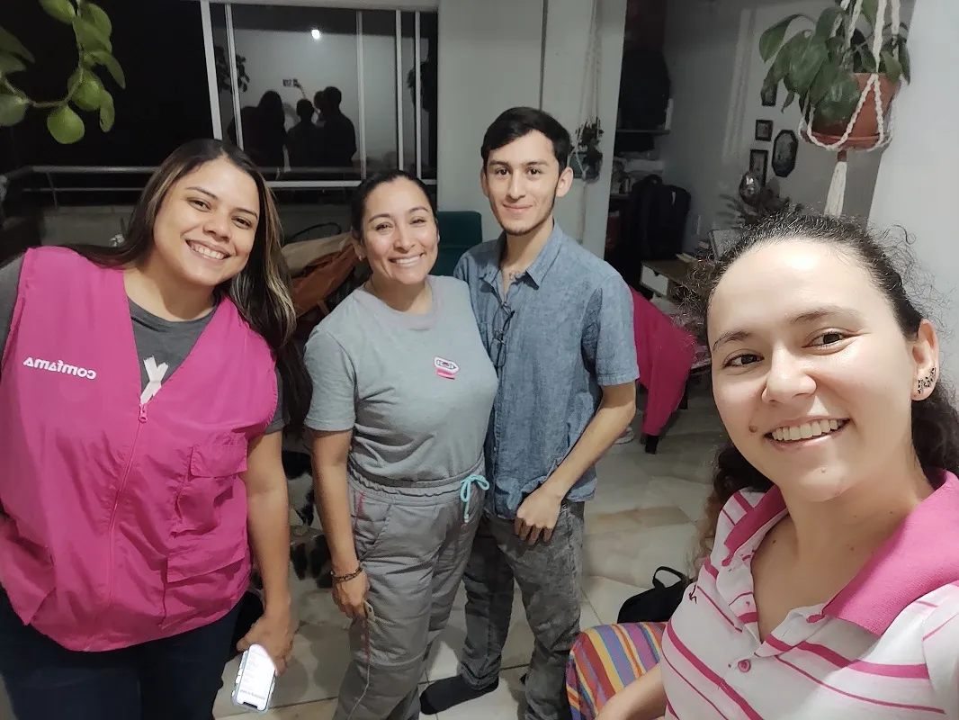 Tres personas de un equipo de terreno sonriendo durante una jornada de campo.